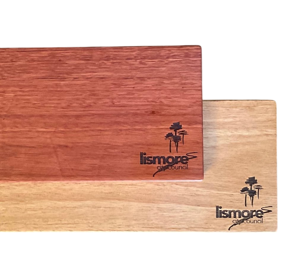 Rectangular corporate cheese board in red and light timber, engraved for Lismore City Council