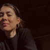 Testimonial profile head shot of a women in low light with a dark background